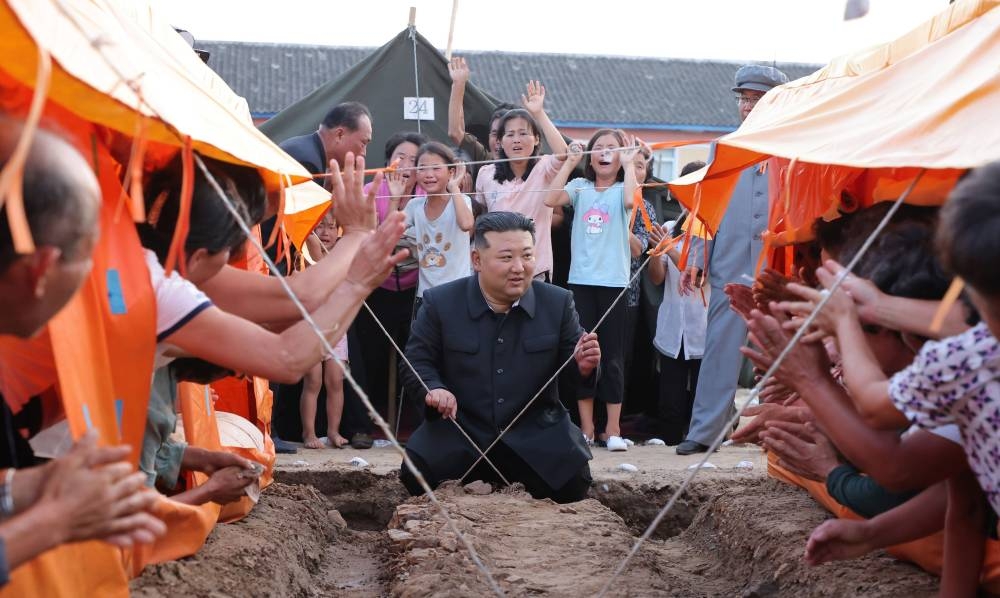 Kim visits victims of North Korea floods and says thousands will be brought to Pyongyang